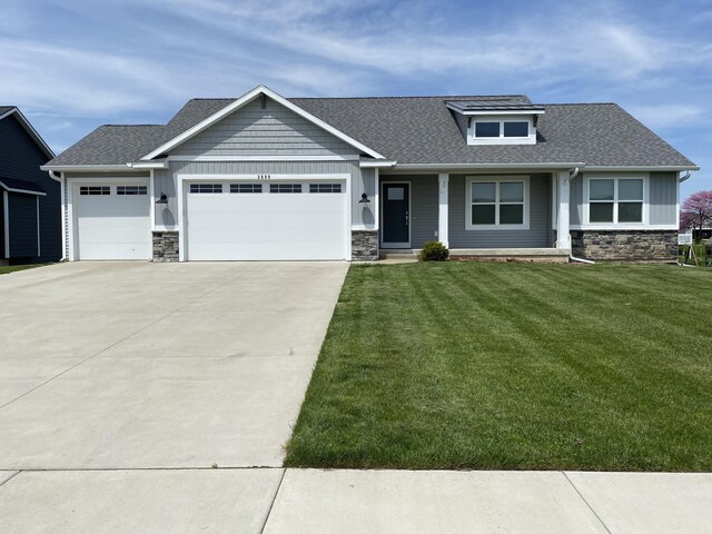 3699 Teton Dr, Hudsonville, MI 49426 - craftsman inspired home featuring stone siding, a garage, driveway, a front lawn, and roof with shingles