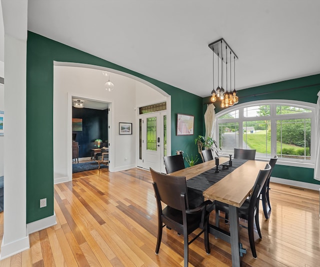 6201 Donovanridge, Dexter, MI 48130 - dining space featuring light wood-style floors, arched walkways, baseboards, and a chandelier