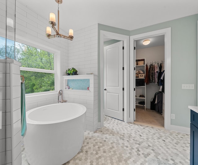 6201 Donovanridge, Dexter, MI 48130 - full bath featuring a soaking tub, a spacious closet, vanity, a chandelier, and tile patterned floors