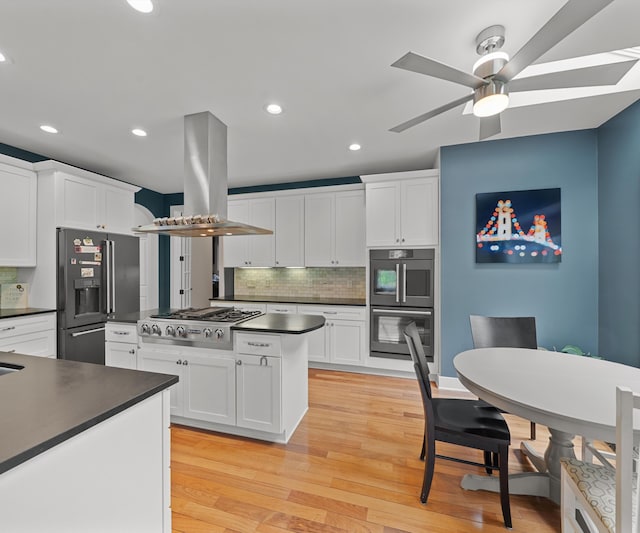 6201 Donovanridge, Dexter, MI 48130 - kitchen with dark countertops, appliances with stainless steel finishes, island exhaust hood, ceiling fan, and decorative backsplash