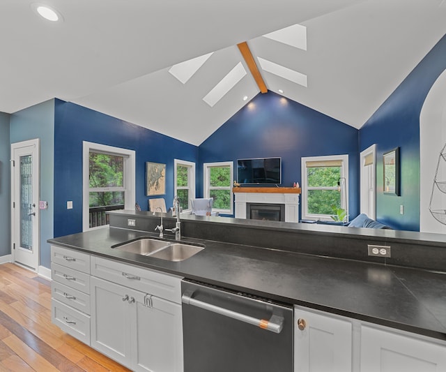 6201 Donovanridge, Dexter, MI 48130 - kitchen featuring stainless steel dishwasher, a sink, a skylight, dark countertops, and open floor plan