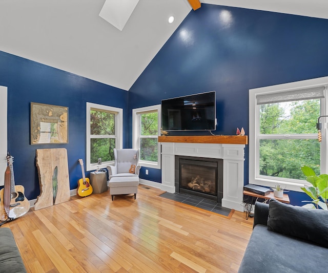 6201 Donovanridge, Dexter, MI 48130 - living room with high vaulted ceiling, a fireplace with flush hearth, hardwood / wood-style floors, a skylight, and baseboards