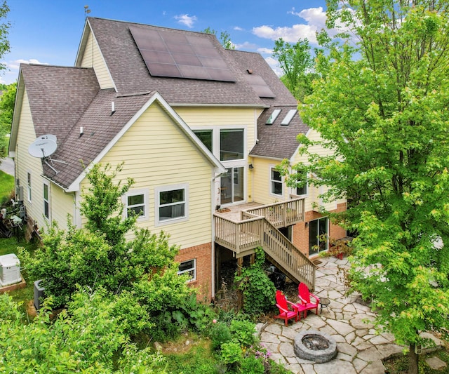 6201 Donovanridge, Dexter, MI 48130 - back of house with a fire pit, roof mounted solar panels, roof with shingles, stairway, and a patio