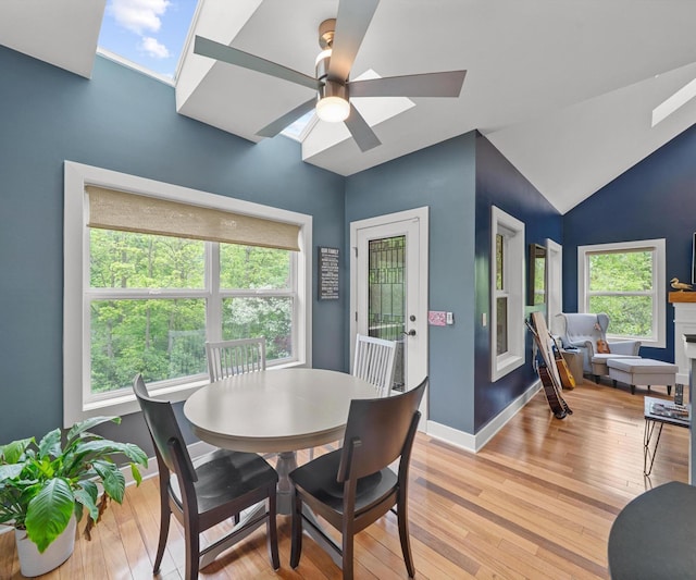6201 Donovanridge, Dexter, MI 48130 - dining room with light wood-style flooring, a ceiling fan, vaulted ceiling, a skylight, and baseboards