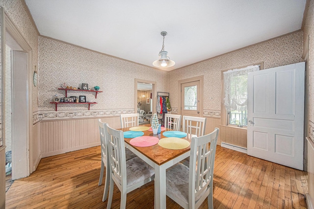 436 Portage St, Grass Lake, MI 49240 - dining room featuring light wood-type flooring, wallpapered walls, a wainscoted wall, ornamental molding, and a baseboard heating unit