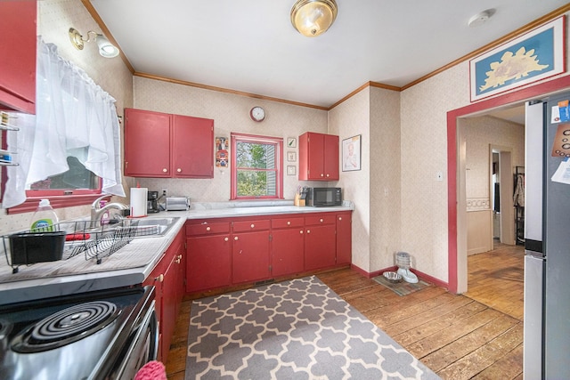 436 Portage St, Grass Lake, MI 49240 - kitchen featuring red cabinets, crown molding, appliances with stainless steel finishes, light wood finished floors, and light countertops