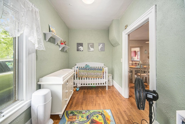 436 Portage St, Grass Lake, MI 49240 - bedroom featuring wood finished floors, a textured wall, and a nursery area