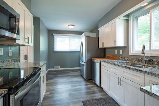 1949 Grove Rd, Ypsilanti, MI 48198 - kitchen with appliances with stainless steel finishes, a sink, white cabinets, stone countertops, and dark wood-style flooring