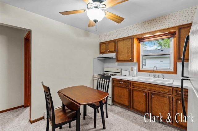 787 Andover St SE Unit 7, Grand Rapids, MI 49548 - kitchen featuring white range with gas cooktop, under cabinet range hood, a sink, freestanding refrigerator, and light colored carpet