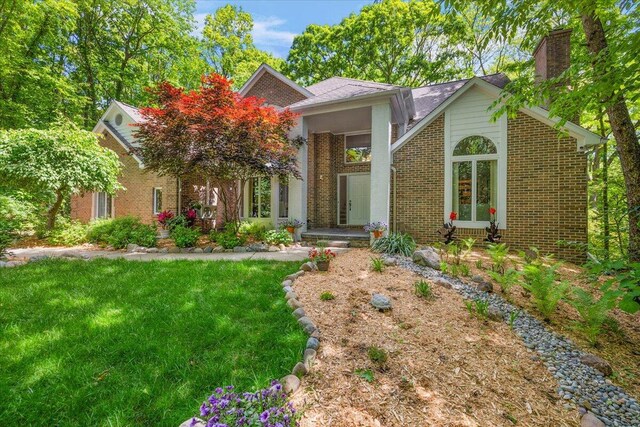3427 E Dobson Pl, Ann Arbor, MI 48105 - view of front facade with brick siding, a chimney, and a front yard