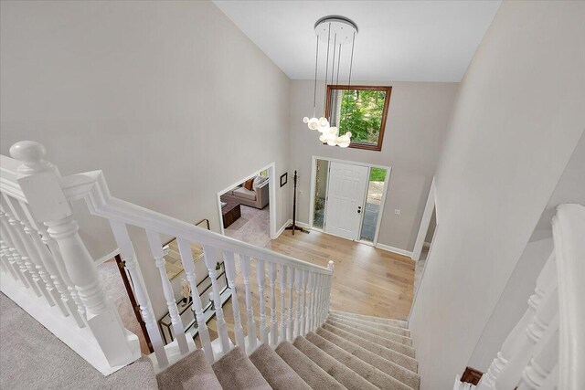 3427 E Dobson Pl, Ann Arbor, MI 48105 - foyer entrance featuring baseboards, wood finished floors, a chandelier, stairway, and high vaulted ceiling