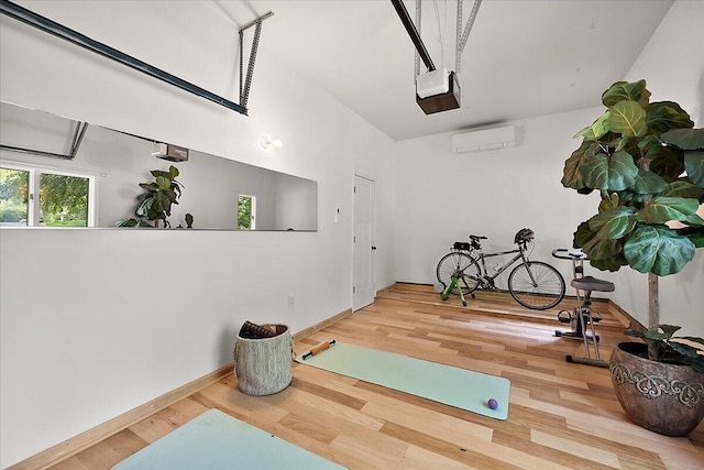 3427 E Dobson Pl, Ann Arbor, MI 48105 - workout area featuring an AC wall unit, wood finished floors, baseboards, and a garage