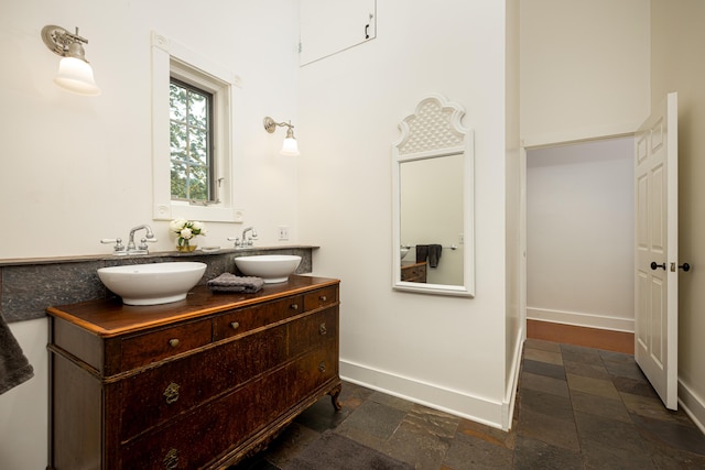 818 S 7th St, Ann Arbor, MI 48103 - bathroom featuring double vanity, baseboards, and stone finish flooring