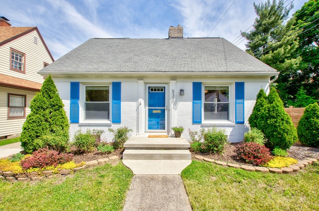 533 Beech St, East Lansing, MI 48823 - bungalow with a chimney, roof with shingles, and brick siding