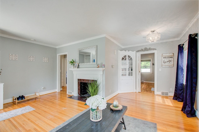 533 Beech St, East Lansing, MI 48823 - living room featuring wood finished floors, a fireplace with flush hearth, crown molding, baseboards, and a chandelier