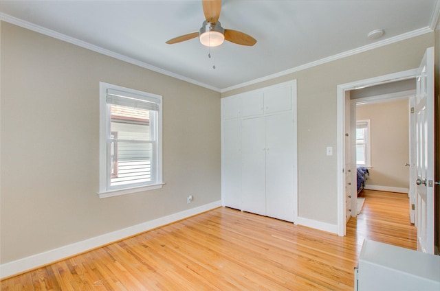 533 Beech St, East Lansing, MI 48823 - unfurnished bedroom featuring light wood-style floors, crown molding, baseboards, a closet, and a ceiling fan