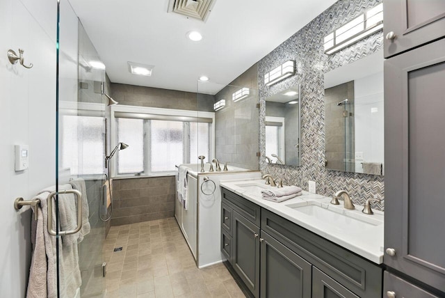 1630 S 3rd St, Niles, MI 49120 - bathroom with tile walls, a stall shower, double vanity, tile patterned flooring, and decorative backsplash