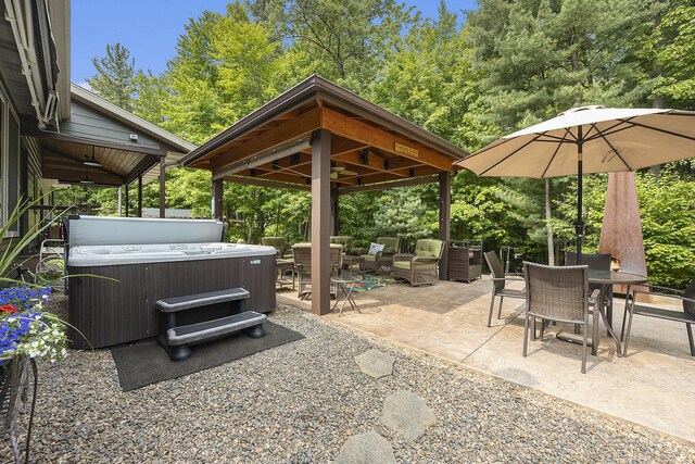 6838 E Michillinda Rd, Twin Lake, MI 49457 - view of patio / terrace featuring a hot tub, a gazebo, outdoor lounge area, outdoor dining space, and view of scattered trees