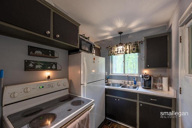 9134 39th Ave, Bitely, MI 49309 - kitchen with white appliances, a sink, dark cabinetry, light countertops, and hanging light fixtures