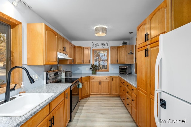 1480 W 72nd St, Newaygo, MI 49337 - kitchen featuring freestanding refrigerator, stainless steel range with electric stovetop, a sink, under cabinet range hood, and light wood finished floors