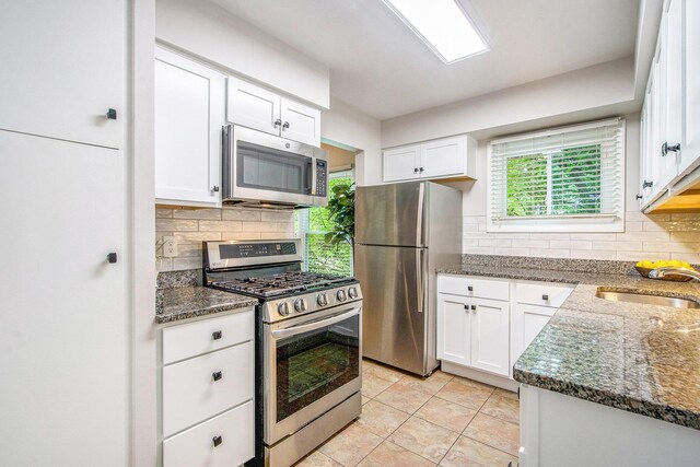429 S 7th St # 1, Ann Arbor, MI 48103 - kitchen with appliances with stainless steel finishes, a sink, dark stone counters, and decorative backsplash