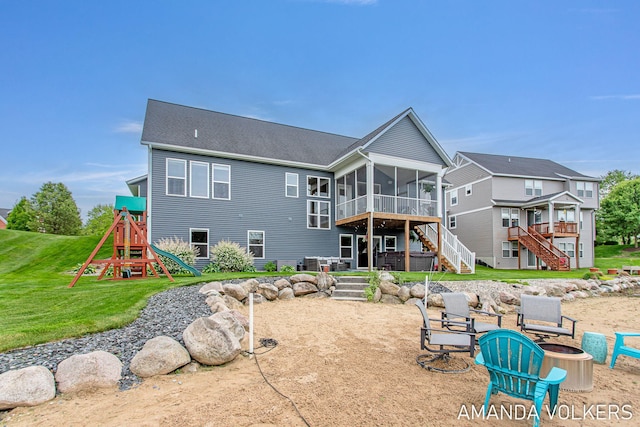1551 Providence Cove Ct, Byron Center, MI 49315 - rear view of property with a sunroom, stairway, an outdoor fire pit, a playground, and a yard