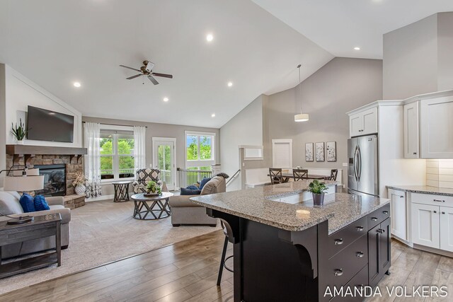 1551 Providence Cove Ct, Byron Center, MI 49315 - kitchen with stainless steel fridge with ice dispenser, open floor plan, white cabinets, wood finished floors, and high vaulted ceiling