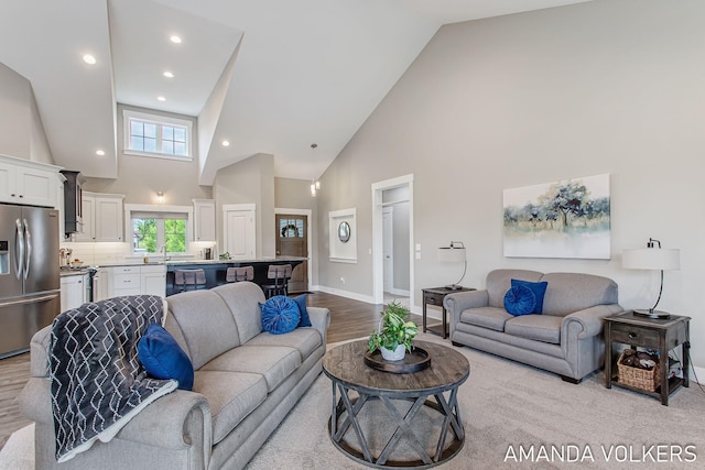 1551 Providence Cove Ct, Byron Center, MI 49315 - living area with high vaulted ceiling, baseboards, light wood-style flooring, and recessed lighting