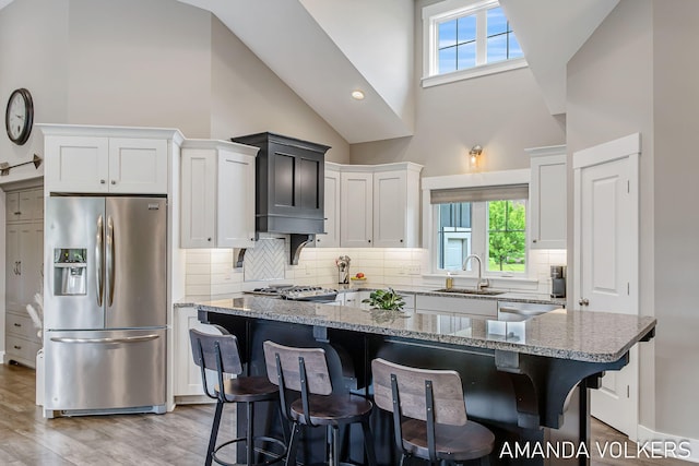1551 Providence Cove Ct, Byron Center, MI 49315 - kitchen featuring appliances with stainless steel finishes, a sink, high vaulted ceiling, plenty of natural light, and light stone countertops