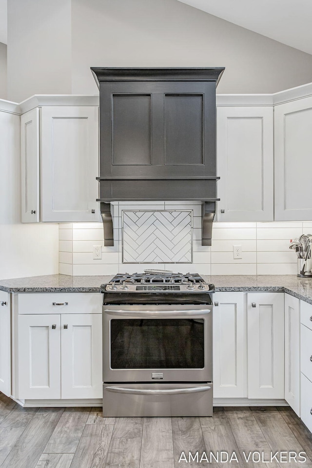 1551 Providence Cove Ct, Byron Center, MI 49315 - kitchen featuring stainless steel gas range oven, lofted ceiling, tasteful backsplash, light stone countertops, and light wood-type flooring