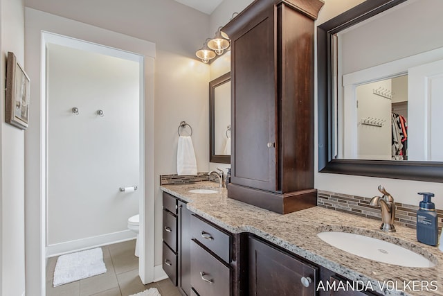 1551 Providence Cove Ct, Byron Center, MI 49315 - bathroom featuring double vanity, tile patterned floors, toilet, baseboards, and a walk in closet