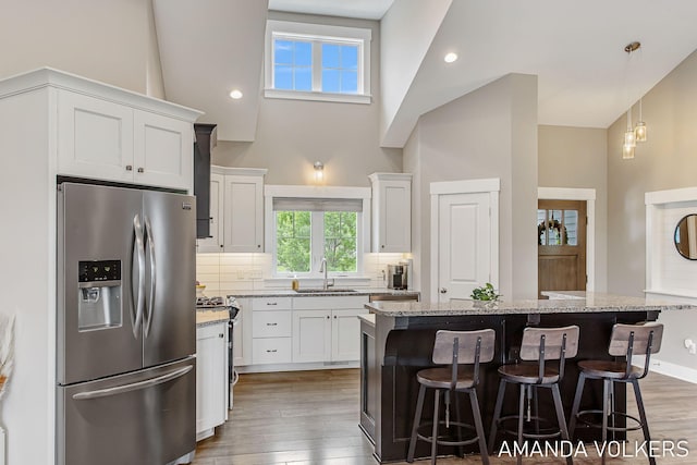 1551 Providence Cove Ct, Byron Center, MI 49315 - kitchen featuring stainless steel fridge with ice dispenser, a sink, gas stove, dark wood-type flooring, and high vaulted ceiling