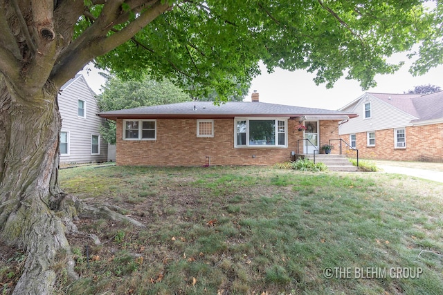 544 Shawmut Blvd NW, Grand Rapids, MI 49504 - view of front of property with a chimney, brick siding, and a front lawn