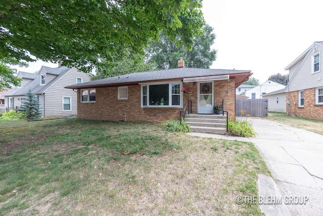 544 Shawmut Blvd NW, Grand Rapids, MI 49504 - view of front of home with a chimney, brick siding, and concrete driveway
