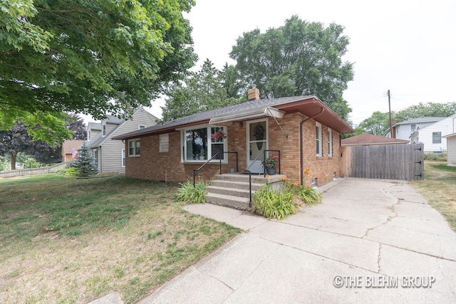 544 Shawmut Blvd NW, Grand Rapids, MI 49504 - view of front of house featuring brick siding, a chimney, and concrete driveway