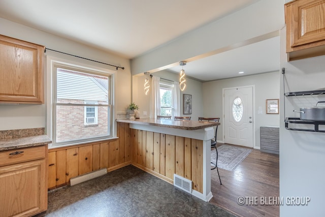 544 Shawmut Blvd NW, Grand Rapids, MI 49504 - kitchen featuring baseboard heating, a breakfast bar, and light brown cabinets