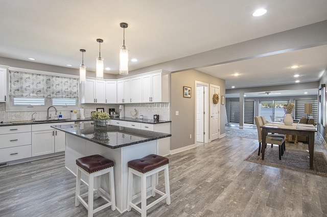 2019 Lakeview Dr, Portage, MI 49002 - kitchen with a kitchen breakfast bar, tasteful backsplash, white cabinetry, recessed lighting, and light wood-type flooring