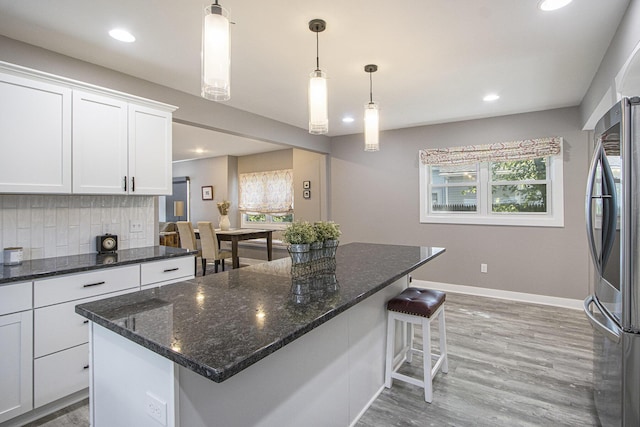 2019 Lakeview Dr, Portage, MI 49002 - kitchen with freestanding refrigerator, white cabinets, decorative backsplash, baseboards, and a breakfast bar area