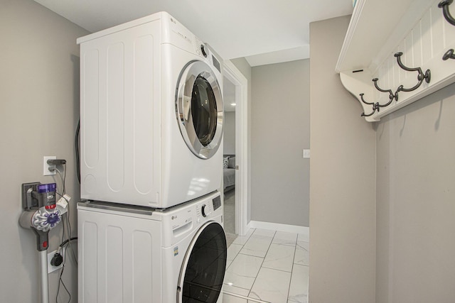 2019 Lakeview Dr, Portage, MI 49002 - washroom with estacked washer and dryer, light marble finish floors, and baseboards