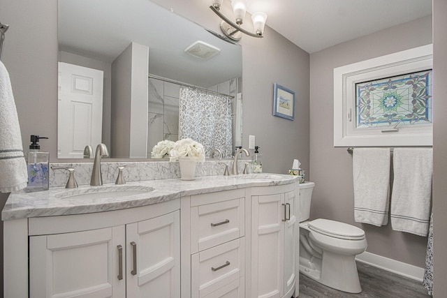 2019 Lakeview Dr, Portage, MI 49002 - bathroom featuring toilet, double vanity, wood finished floors, curtained shower, and baseboards