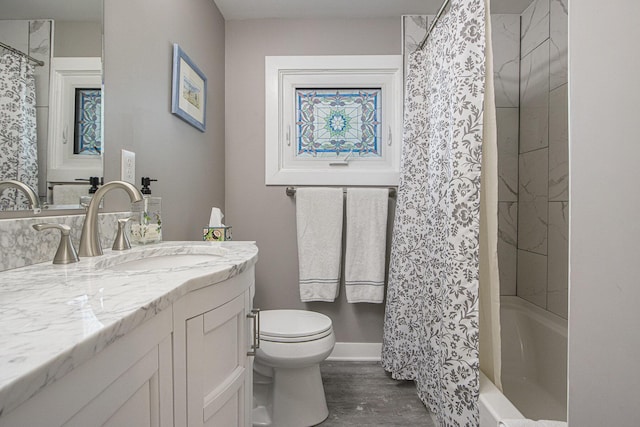 2019 Lakeview Dr, Portage, MI 49002 - bathroom featuring vanity, toilet, wood finished floors, shower / bath combo, and baseboards