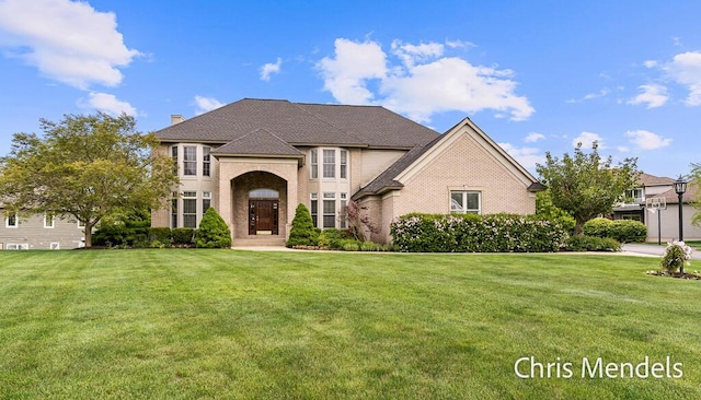 150 Bay Circle Dr, Holland, MI 49424 - french country style house with brick siding, a front yard, and a chimney