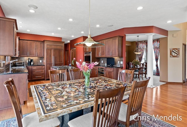 150 Bay Circle Dr, Holland, MI 49424 - dining room with beverage cooler, light wood-type flooring, decorative columns, and recessed lighting