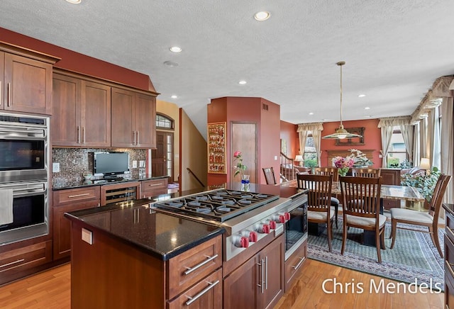 150 Bay Circle Dr, Holland, MI 49424 - kitchen featuring stainless steel appliances, a center island, light wood-style flooring, recessed lighting, and a textured ceiling
