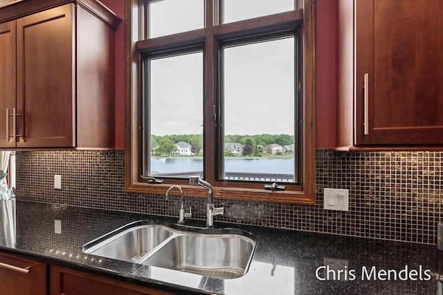150 Bay Circle Dr, Holland, MI 49424 - kitchen featuring a sink, decorative backsplash, and dark stone counters
