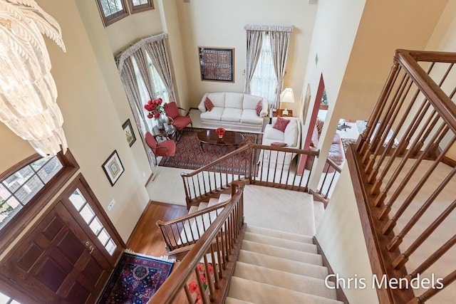 150 Bay Circle Dr, Holland, MI 49424 - staircase featuring a high ceiling, plenty of natural light, and wood finished floors