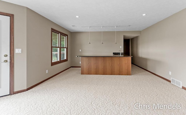 150 Bay Circle Dr, Holland, MI 49424 - kitchen with light carpet, baseboards, rail lighting, recessed lighting, and a kitchen island with sink