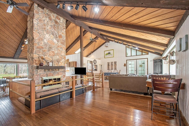 9701 Kruger Rd, Union Pier, MI 49129 - living room with a ceiling fan, wood-type flooring, wood ceiling with exposed beams, a stone fireplace, and high vaulted ceiling
