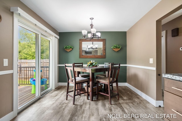 16507 Sleeper St, Grand Haven, MI 49417 - dining space featuring a chandelier, wood finished floors, and baseboards
