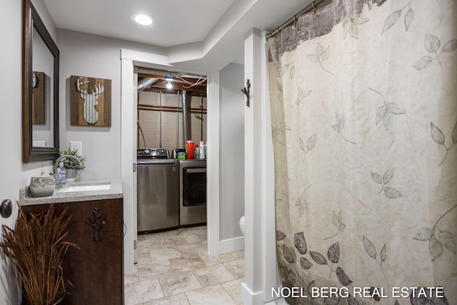 16507 Sleeper St, Grand Haven, MI 49417 - bathroom featuring washer and dryer, vanity, toilet, a shower with curtain, and baseboards